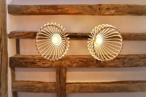 a pair of gold sunburst mirrors on a wooden shelf at LE BAS CHITRAY in Ménil