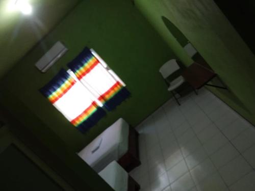 a bathroom with a window with a rainbow curtain at HOTEL ESTRELLA HUASTECA in Aquismón