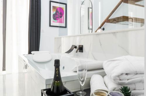 ein weißes Badezimmer mit einer Flasche Champagner auf dem Tisch in der Unterkunft Apartamentos Élite - Art Collection - Andy in Merida