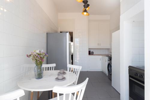 a kitchen with a table and chairs and a refrigerator at Estrela Guesthouse in Lisbon
