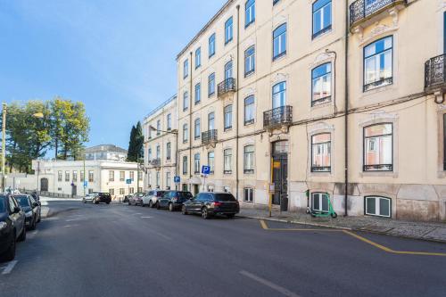 a street with cars parked next to a large building at Estrela Guesthouse in Lisbon