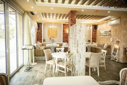 un ristorante con tavoli e sedie in una stanza di семеен хотел Прованс Ахелой ad Aheloy