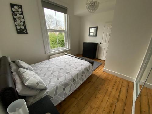 a bedroom with a bed and a window at Lovely 2 Bedroom Flat Wifi Close to the beach in Bournemouth