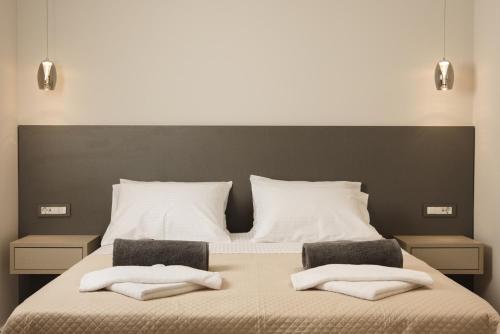 a bedroom with a large bed with two towels on it at Villa De Reve in Laganas