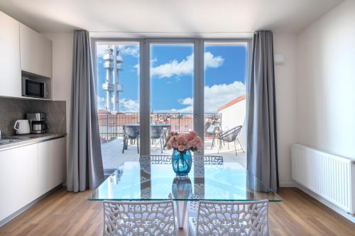 a glass table with a vase of flowers on it at Hidden Art Boutique Residence by Dwellfort in Prague