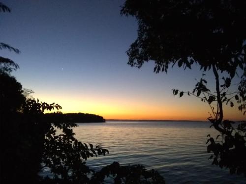 a sunset over a body of water at Parana Riverside Guest House - Posadas in Posadas