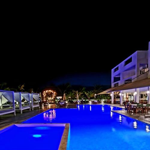a swimming pool with blue lighting at night at Visiwa Beach Resort in Watamu