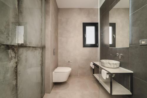 a bathroom with a toilet and a sink at Villa De Reve in Laganas