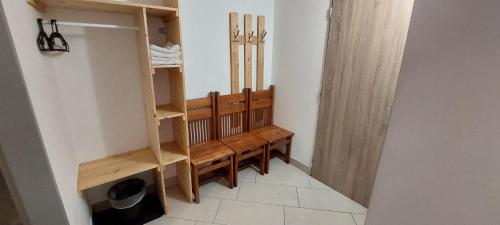 a room with a row of wooden benches in a room at Horská chata Plzeňka Pernink in Pernink