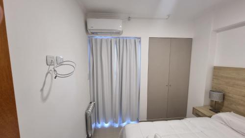 1 dormitorio con 1 cama y una ventana con luces azules en Hermoso departamento, excelente ubicación. en Salta