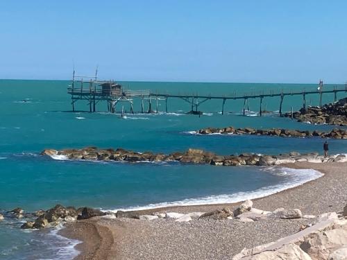 a pier in the water next to a beach at The Angels House in Fossacesia