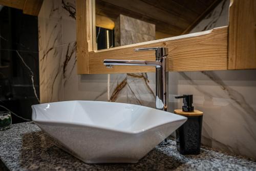 a white sink in a bathroom with a faucet at Dworek nad Jałowcami z Jacuzzi in Biały Dunajec