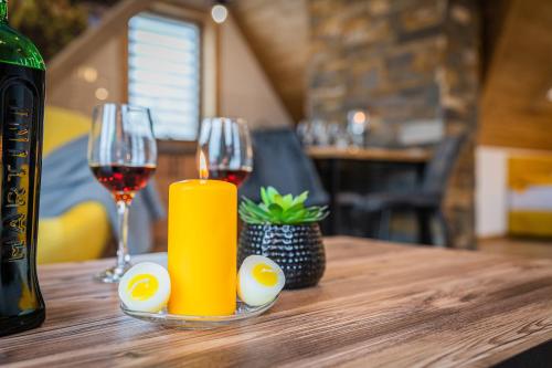 a table with two glasses of wine and a candle at Dworek nad Jałowcami z Jacuzzi in Biały Dunajec