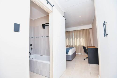 a bathroom with a bed and a tub in a room at Unit 508 at Menlyn Place in Pretoria