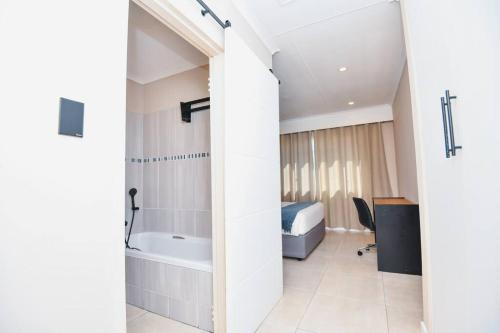 Pretoria的住宿－Unit 508 at Menlyn Place，客房内的浴室设有床和浴缸
