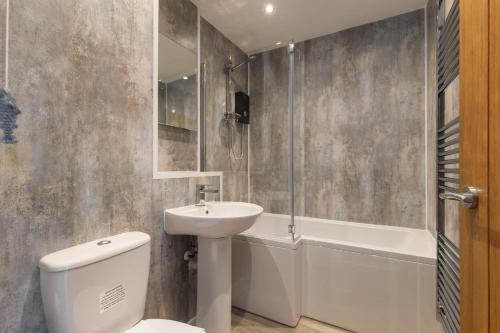 a bathroom with a toilet and a sink and a tub at Coedrath Park 20 - Modern Apartment, Close to the Beach in Saundersfoot