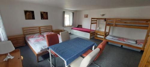 a room with two bunk beds and a table and chairs at Horská chata Plzeňka Pernink in Pernink