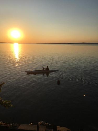 a person in a boat on the water at sunset at Parana Riverside Guest House - Posadas in Posadas