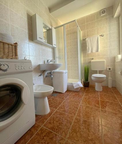 a bathroom with a toilet and a washing machine at Apartman Rosi in Dramalj