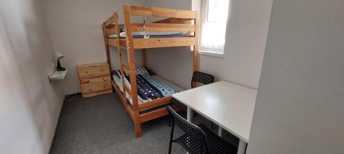 a room with a desk and a bunk bed and a table at Horská chata Plzeňka Pernink in Pernink