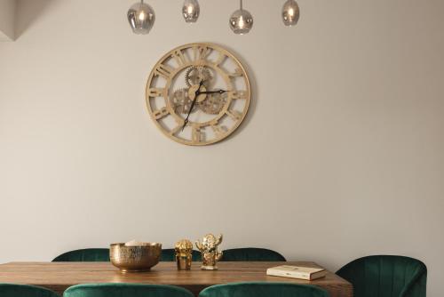a clock hanging on a wall above a table at Villa De Reve in Laganas