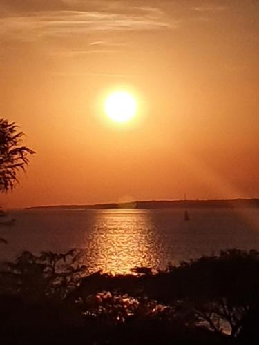 a sunset over a body of water with the sun at Parana Riverside Guest House - Posadas in Posadas
