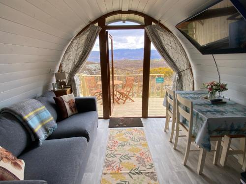 a living room with a couch and a table at Duirinish Pods with Private Hot Tubs and Duirinish Bothy with No Hot Tub in Plockton