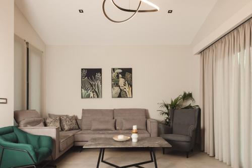 a living room with a couch and two chairs at Villa De Reve in Laganas