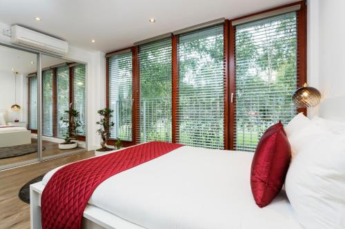 1 dormitorio con cama blanca y ventanas grandes en Park View Apartments en Londres
