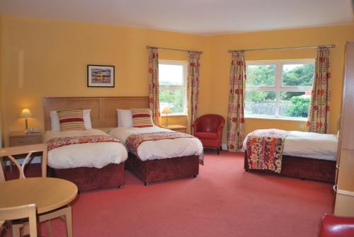 um quarto de hotel com duas camas e uma mesa em West View Accomodation em Louisburgh