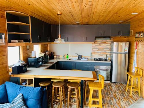 - une cuisine avec un comptoir et quelques tabourets dans l'établissement Pichilemu Loft 51, à Pichilemu