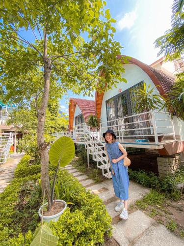 a woman standing in front of a house at Areca Bungalow in Phong Nha
