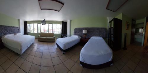 a living room with two beds and a couch at Hotel el Cortes in Aguascalientes