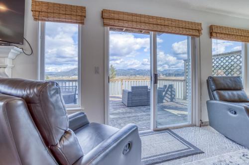 a living room with a couch and sliding glass doors at Coastal River Haven - Meredith Lodging in Nehalem