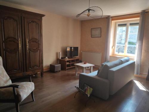 ein Wohnzimmer mit einem Sofa und einem Stuhl in der Unterkunft gite chez l'oncle jules in Velesmes