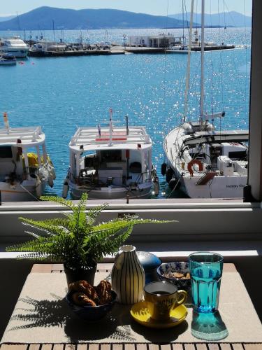 a table with a view of a marina with boats at Aegina Port Apt 4 in Egina