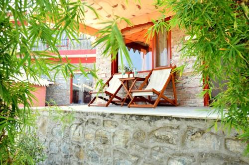 dos sillas sentadas en el porche de una casa en The Sky Imperial Jungle Camp Resort, en Kumbhalgarh