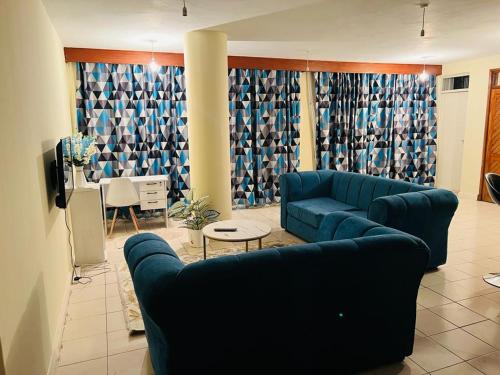 a living room with a blue couch and a table at Swan Lakeview 2 Apartment with WiFi,Netflix Free Parking,Sunset,Lakeview in Kisumu