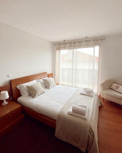 a bedroom with a large bed with two towels on it at Hill & Beach house in Viana do Castelo