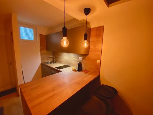 - une cuisine avec un comptoir en bois et deux lumières dans l'établissement Studio apartment F&J, à Sveti Filip i Jakov
