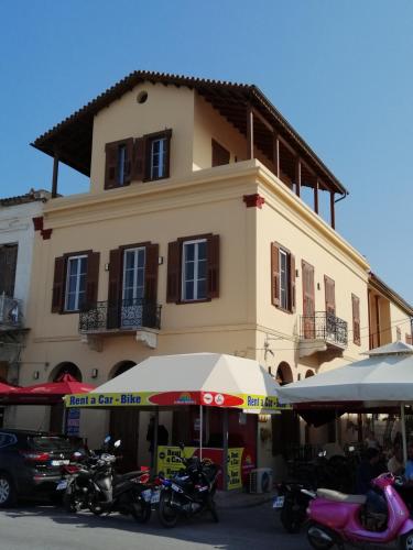 a large building with motorcycles parked in front of it at Aegina Port Apt 4 in Egina