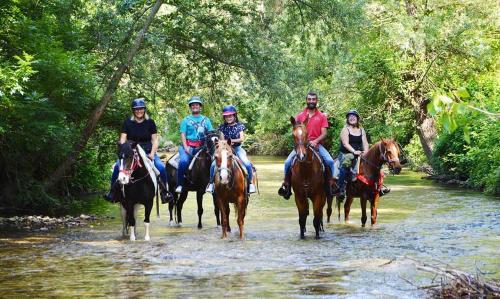 a group of people riding horses through a river at Villa Ola in Barrea