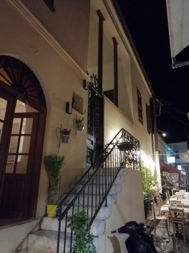 a black dog sitting on the stairs of a building at Aegina Port Apt 4 in Egina