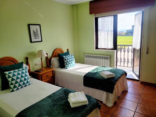 a bedroom with two beds and a window with a view at Vilariño Moscoso in Arzúa