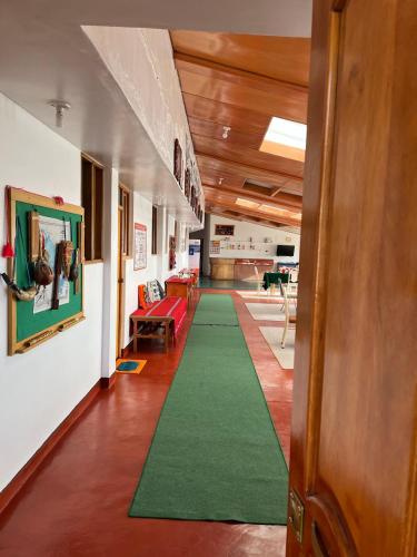 a hallway with a green carpet in a building at Hotel Wiñay Pacha Inn in Puno