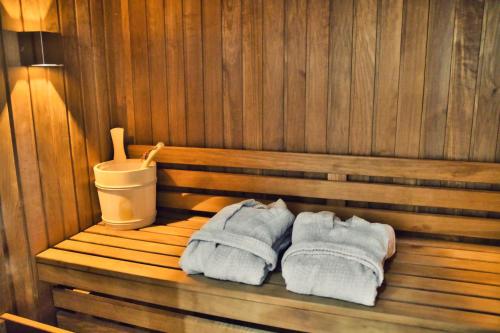 due asciugamani seduti su una panchina in una sauna di L’Oxalis villa, Sauna et Jaccuzi privatif a Bullion