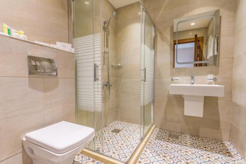 a bathroom with a shower and a toilet and a sink at The Seventh Star Hotel Suites in Amman