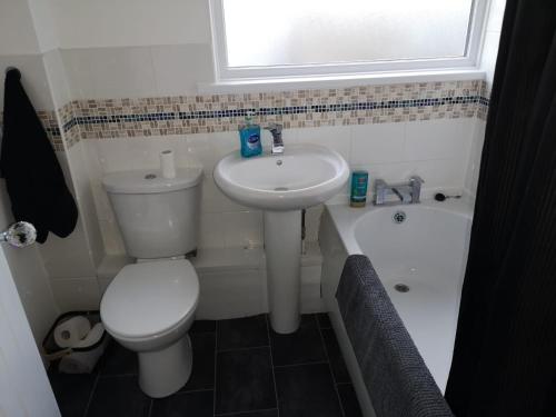 a small bathroom with a toilet and a sink at Ffrith House in Prestatyn