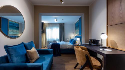 Habitación de hotel con sofá azul y cama en Delphi Hotel & Restaurant en Neu Wulmstorf