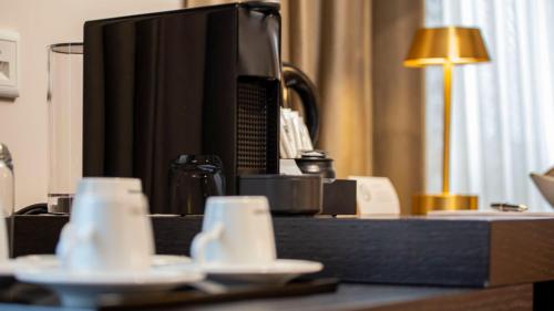 a desk with a tv and cups on a table at Delphi Hotel & Restaurant in Neu Wulmstorf